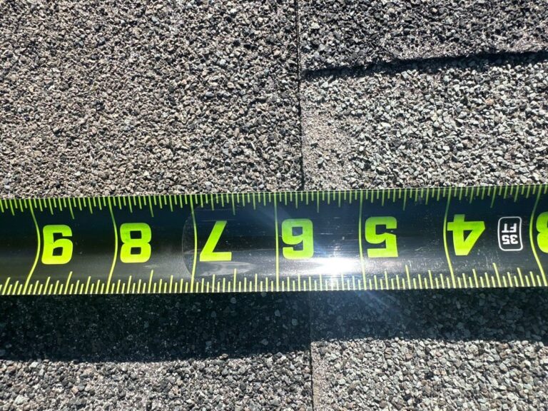 Measuring shingle exposure during a Broomfield roof inspection, April 2026