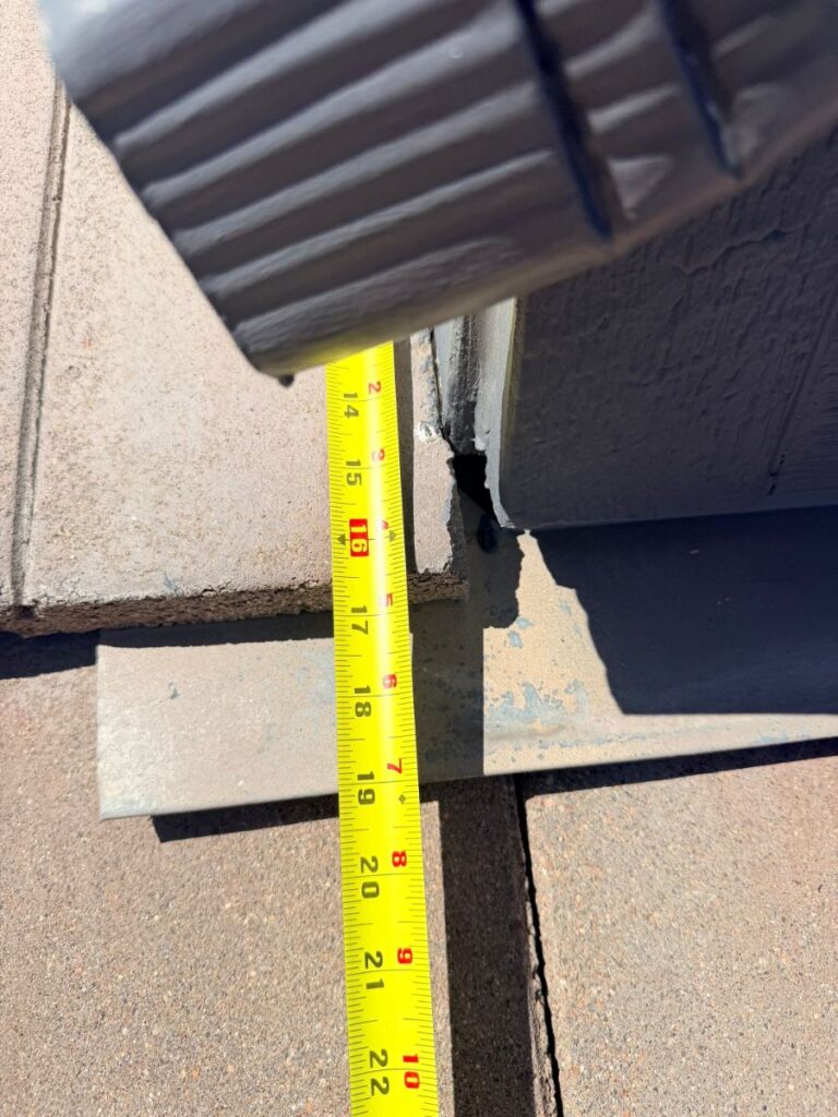 Tape measure documenting tile and flashing dimensions on a Castle Rock roof