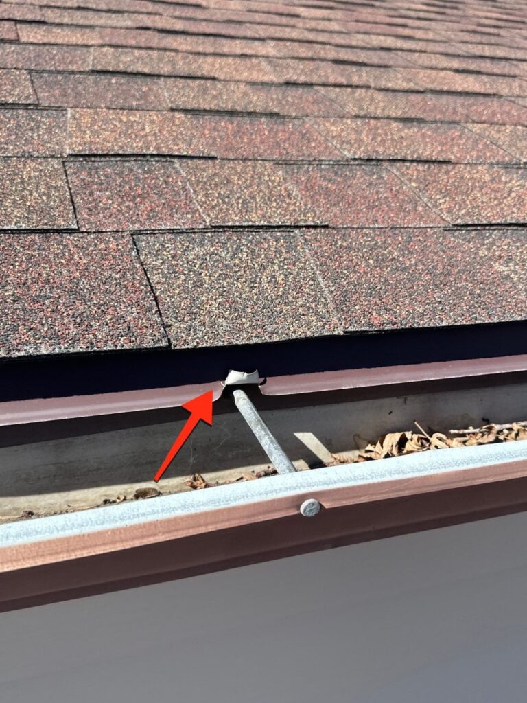 Arrow marking a drip edge and gutter problem on a Northglenn roof